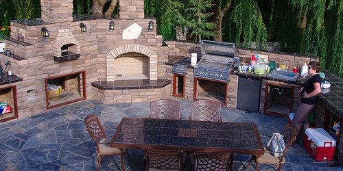 adding an outdoor kitchen is one hardscape idea for a large backyard makeover